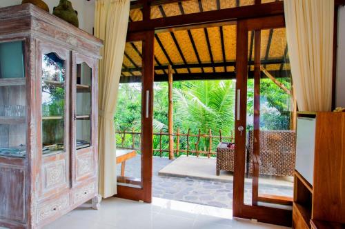 a room with an open door to a patio at Temple Retreat Rumah Cantik in Banjar