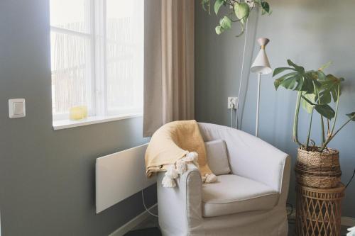 a living room with a white chair and a lamp at Valleviken Hotell in Valleviken