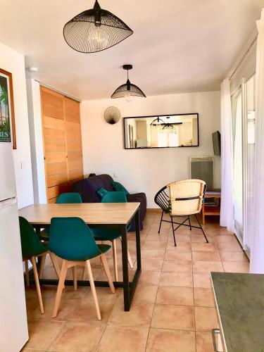 une cuisine et un salon avec une table et des chaises dans l'établissement Giens-T2 charme-7m à pied plage - Rez de jardin, à Hyères