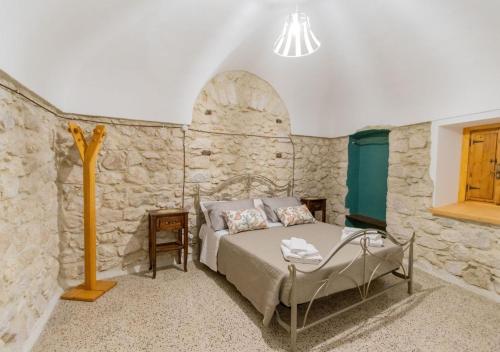 a bedroom with a bed and a stone wall at La casa nel Borgo in San Donato Val di Comino