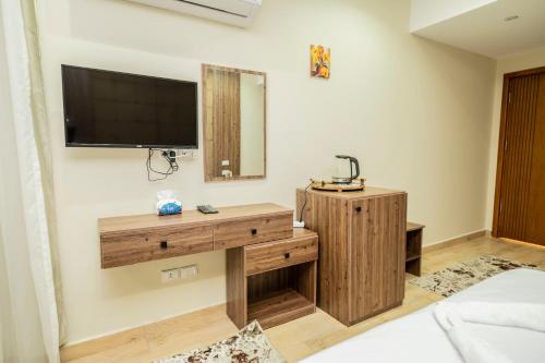 a bedroom with a flat screen tv on the wall at Amon Pyramids View Inn in Cairo