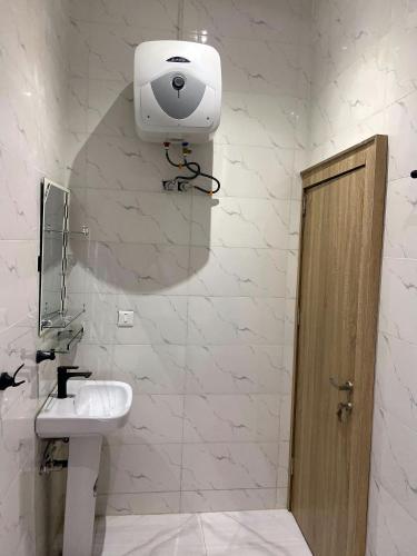 a bathroom with a sink and a camera on the wall at E-Vac Homes Apartments Abuja in Abuja