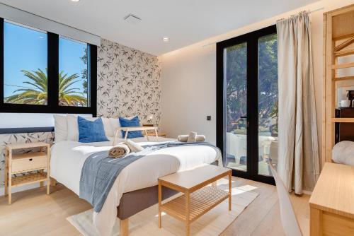 une chambre avec un grand lit et de grandes fenêtres dans l'établissement Las Dunas de Santa Catalina Boutique House, à Las Palmas de Gran Canaria
