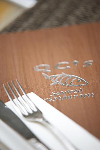 a wooden table with a napkin and fork and knife at Quinlan & Cooke Boutique Townhouse and QCs Seafood Restaurant in Cahersiveen