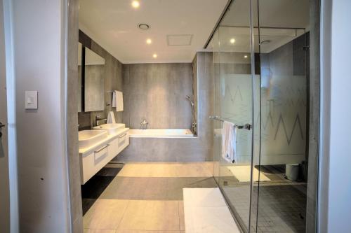a bathroom with a shower and a sink and a tub at Masingita Towers Hotel and SPA in Johannesburg