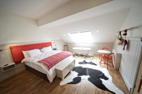 a bedroom with a large bed with a red headboard at Quinlan & Cooke Boutique Townhouse and QCs Seafood Restaurant in Cahersiveen