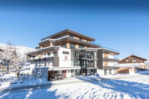 a large building in the snow with snow at Hubertus Logis Apartments in Brixen im Thale