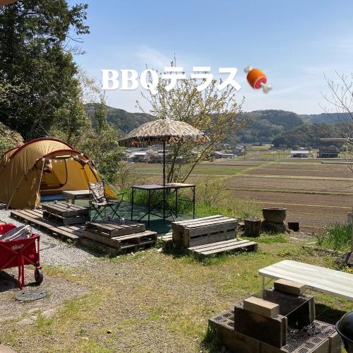 a tent and a picnic table and a kite in the sky at エコビレッジ地球人村 in Shimoichi
