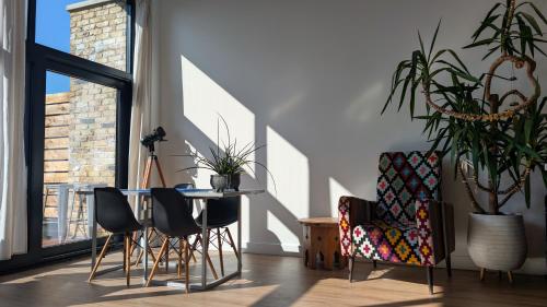 a living room with a table and chairs and a plant at Tranquil & Bright by The Canal in London