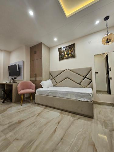 a bedroom with a bed and a desk and a television at Hotel Prince Diamond in Varanasi