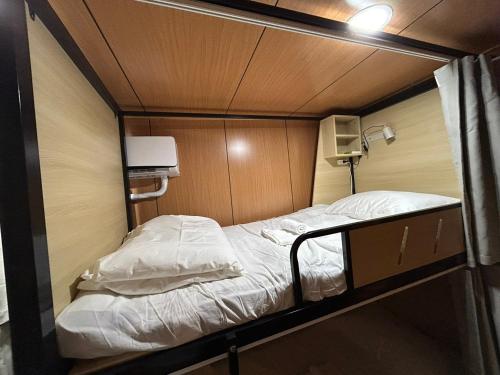 a small bed in a small room with at B&B American Style cabin 5 minutes from the sea in Hengchun