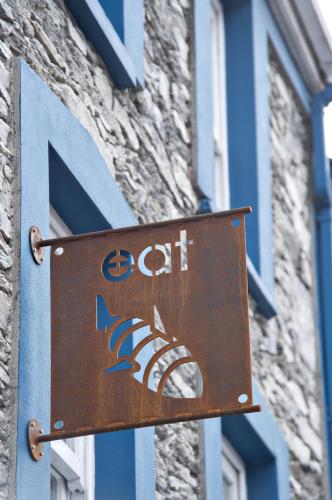 a sign for a cat on the side of a building at Quinlan & Cooke Boutique Townhouse and QCs Seafood Restaurant in Cahersiveen