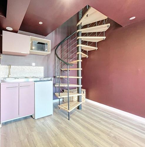 un escalier en colimaçon dans une cuisine à côté d'un mur dans l'établissement Parenthèse Romantique - Love Room avec Jacuzzi, à Gradignan