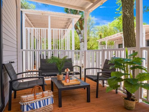 a screened porch with chairs and a table at Club del Sole Adriatico Cervia Easy Camping Village in Cervia