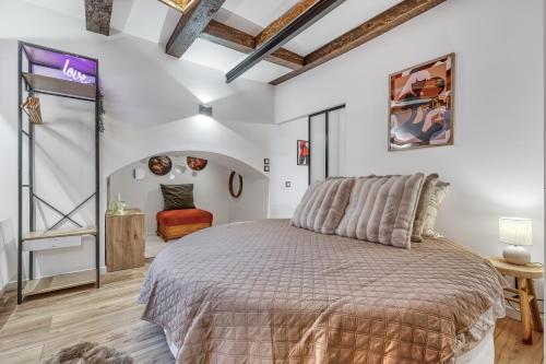 a bedroom with a large bed and a chair at Secret room jacuzzi vieille ville Annecy in Annecy