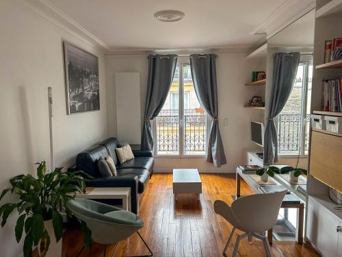 un salon avec un canapé et une table dans l'établissement Bastille Hideaway, à Paris