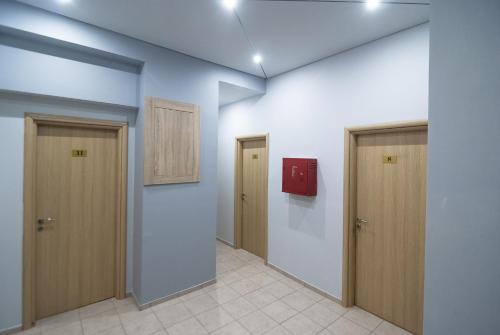 a hallway with three doors and a red box on the wall at Elikon in Athens