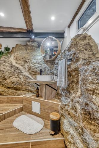 La salle de bains est pourvue d'un grand mur en pierre. dans l'établissement Secret room jacuzzi vieille ville Annecy, à Annecy