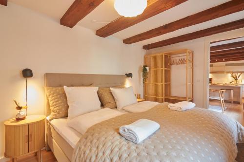 a bedroom with a bed with two towels on it at Warm 3BR Loft with Exposed Beams in Copenhagen