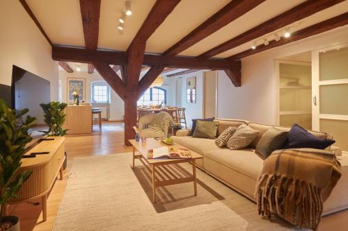 a living room with a couch and a table at Warm 3BR Loft with Exposed Beams in Copenhagen
