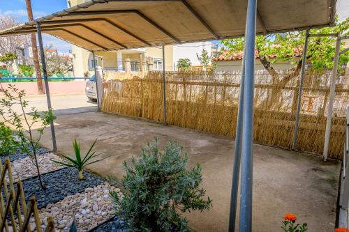 a covered patio with a fence in a yard at HomeStory AXD in Alexandroupoli