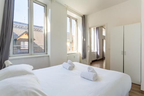 une chambre avec un lit blanc avec deux serviettes dessus dans l'établissement Thiergarten - Charmant T2 à proximité de la gare, à Strasbourg