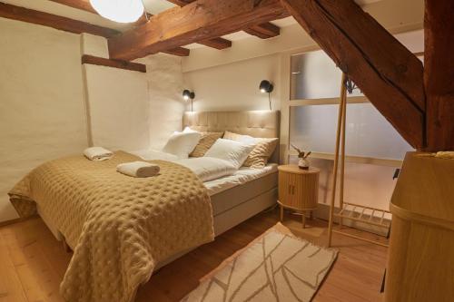 a bedroom with a bed and a large window at Warm 3BR Loft with Exposed Beams in Copenhagen