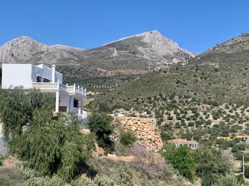 a white house on the side of a mountain at 3 bedroom holiday home Alcaucin with private pool and mountain view in Alcaucín