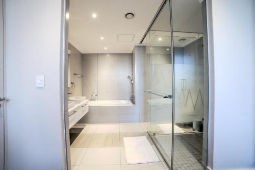 a bathroom with a glass shower and a tub at Masingita Towers Hotel and SPA in Johannesburg
