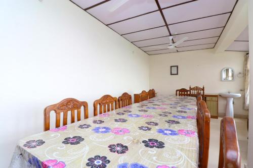 a dining room with a table and eight chairs at Hotel O Country Lodge in Dharamshala