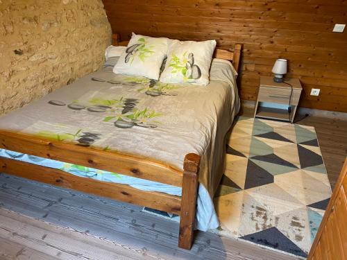 un lit dans une chambre avec un mur en bois dans l'établissement Gite en pierres à la campagne, à Tamniès