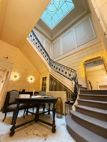 a room with a piano and stairs with a skylight at Hotel de Maître de Vaughan in Brussels
