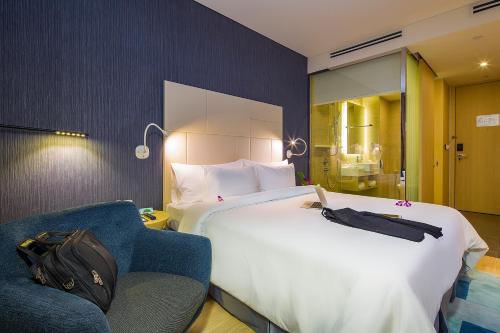 a hotel room with a large bed and a chair at Liberty Central Saigon Riverside Hotel in Ho Chi Minh City