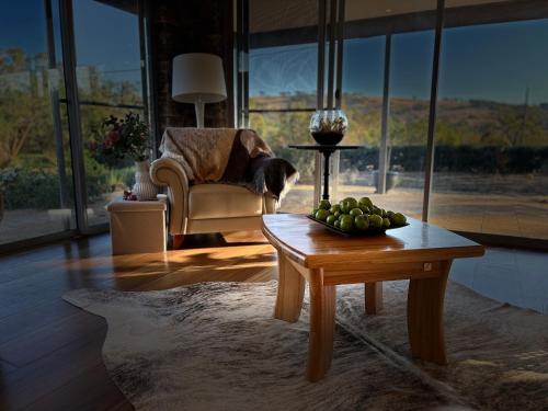 a dog sitting in a chair in a living room with a table at Toodyay Upon Avon Guest House and Gallery in Toodyay