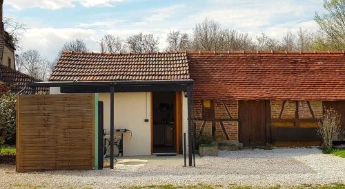 a small house with a brown roof and a door at Joli studio à la ferme avec patio couvert in Saint-Germain-du-Bois
