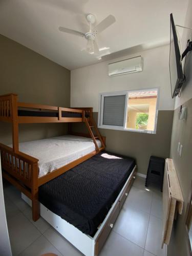 a bedroom with two bunk beds and a window at Chalés do Bona Loft 18 in Ubatuba