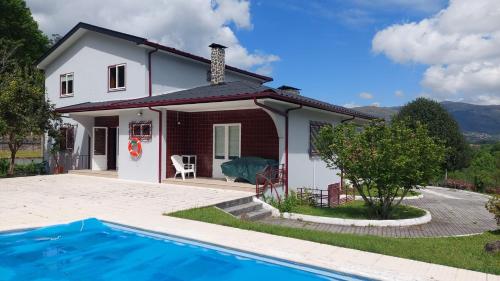 a house with a swimming pool in front of it at Quintinha de Sabadim - 500 metros da ecovia de Sistelo in Arcos de Valdevez