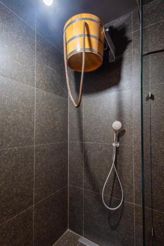 a shower with a bucket on the wall at Hotel JISKRA na Čeladné in Čeladná