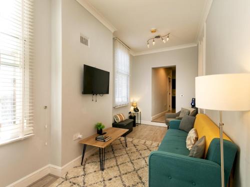 a living room with a couch and a tv at Central Gem Plush Beds -Walk to Attractions - Pass the Keys in Nottingham