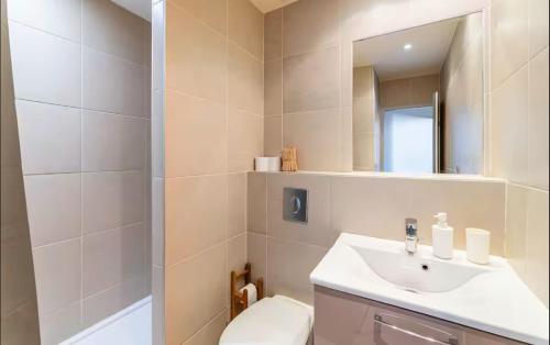 une salle de bain avec un lavabo, des toilettes et un miroir dans l'établissement Grand Studio avec vue sur le Vieux Port, à Marseille