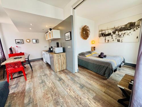 une chambre avec un lit et un bureau dans une pièce dans l'établissement Grand Studio avec vue sur le Vieux Port, à Marseille