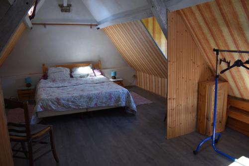 une chambre avec un lit dans un grenier dans l'établissement les écuries d'Ailly, à La Celle-sous-Gouzon