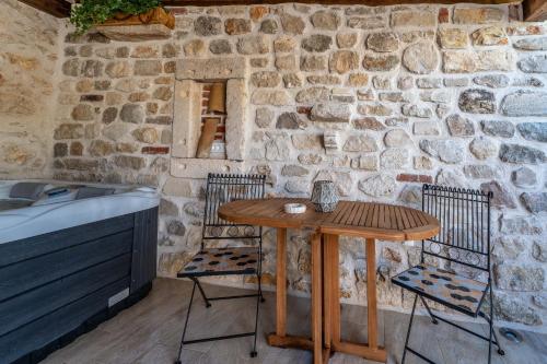 a table and chairs in front of a stone wall at Roman style stone Villa Lux Solis in Nin