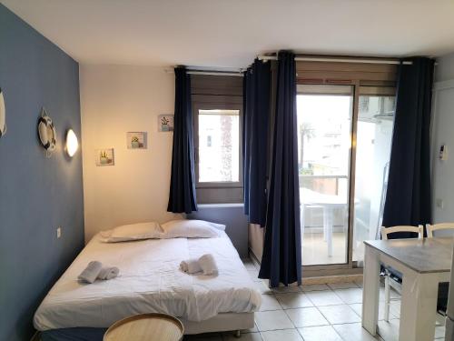 une chambre avec un lit, une table et une fenêtre dans l'établissement Résidence Graziella Studio 402, à Juan-les-Pins