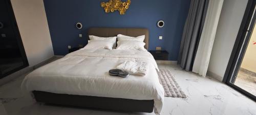 a blue bedroom with a large bed with shoes on it at Chambres d'Hôtes Centre Ville in Dakar