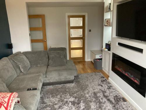 a living room with a couch and a flat screen tv at Beautiful Property Close To London in Potters Bar