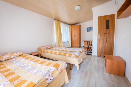 a hotel room with two beds and a table at Domki Leśne Uroczysko in Ustka