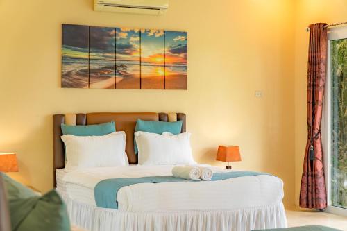 a bedroom with a bed with a painting on the wall at The Hawk's Nest Resort in Sabong