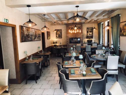 a restaurant dining room with tables and chairs at Logis Hôtel Restaurant Spa L'auberge Du President in Cormeilles