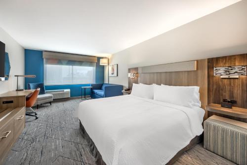 a hotel room with a large bed and a desk at Holiday Inn Express & Suites Nashville West End - Univ Area by IHG in Nashville